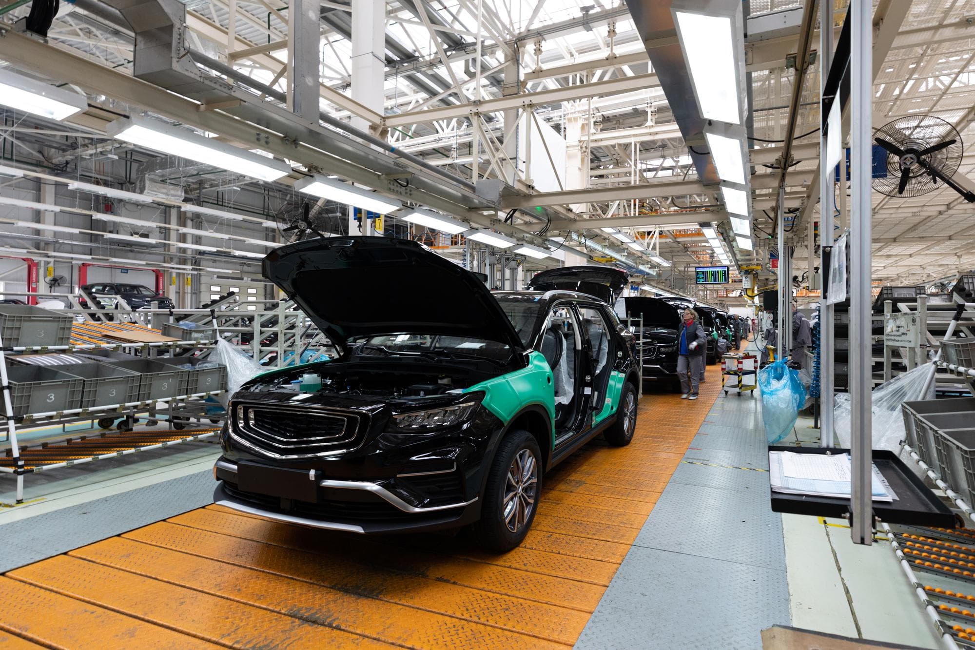 Automobile manufacturing facility with cars on assembly line